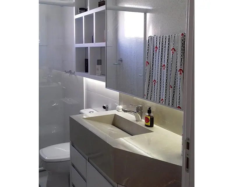 Banheiro com nichos iluminados e gabinete cinza