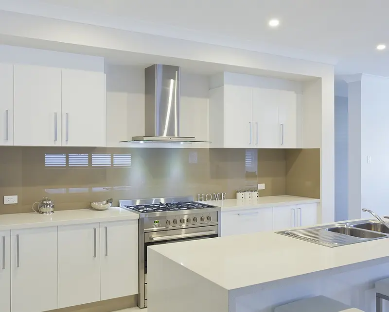 Cozinha branca com bancada linear e coifa de inox