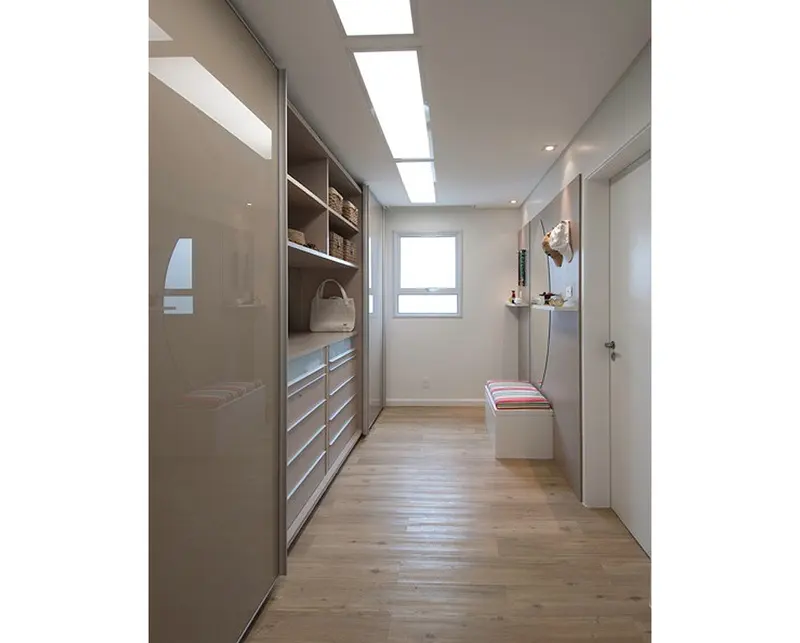 Closet em corredor com armários claros e gaveteiro