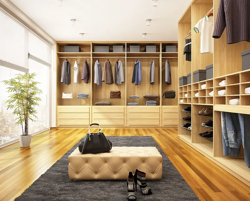 Closet amplo com prateleiras de madeira, cabideiros e pufe central