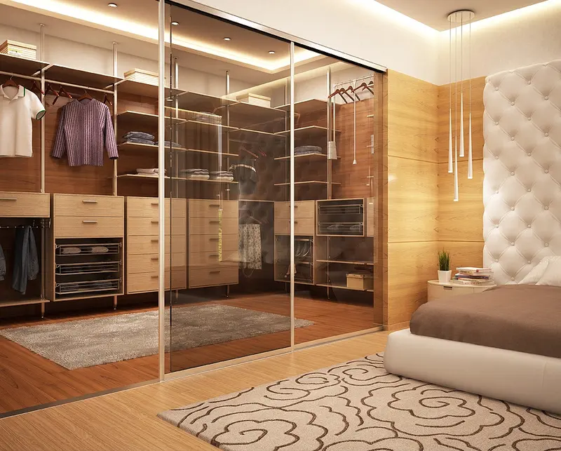 Closet com portas de vidro, cabideiros iluminados e cabeceira estofada