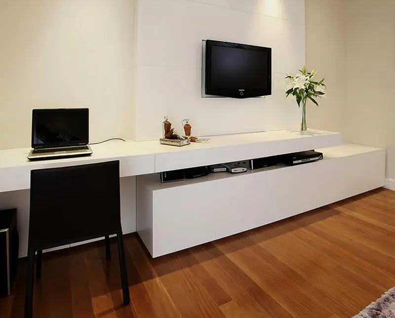 Sala com rack branco extenso, home office e TV